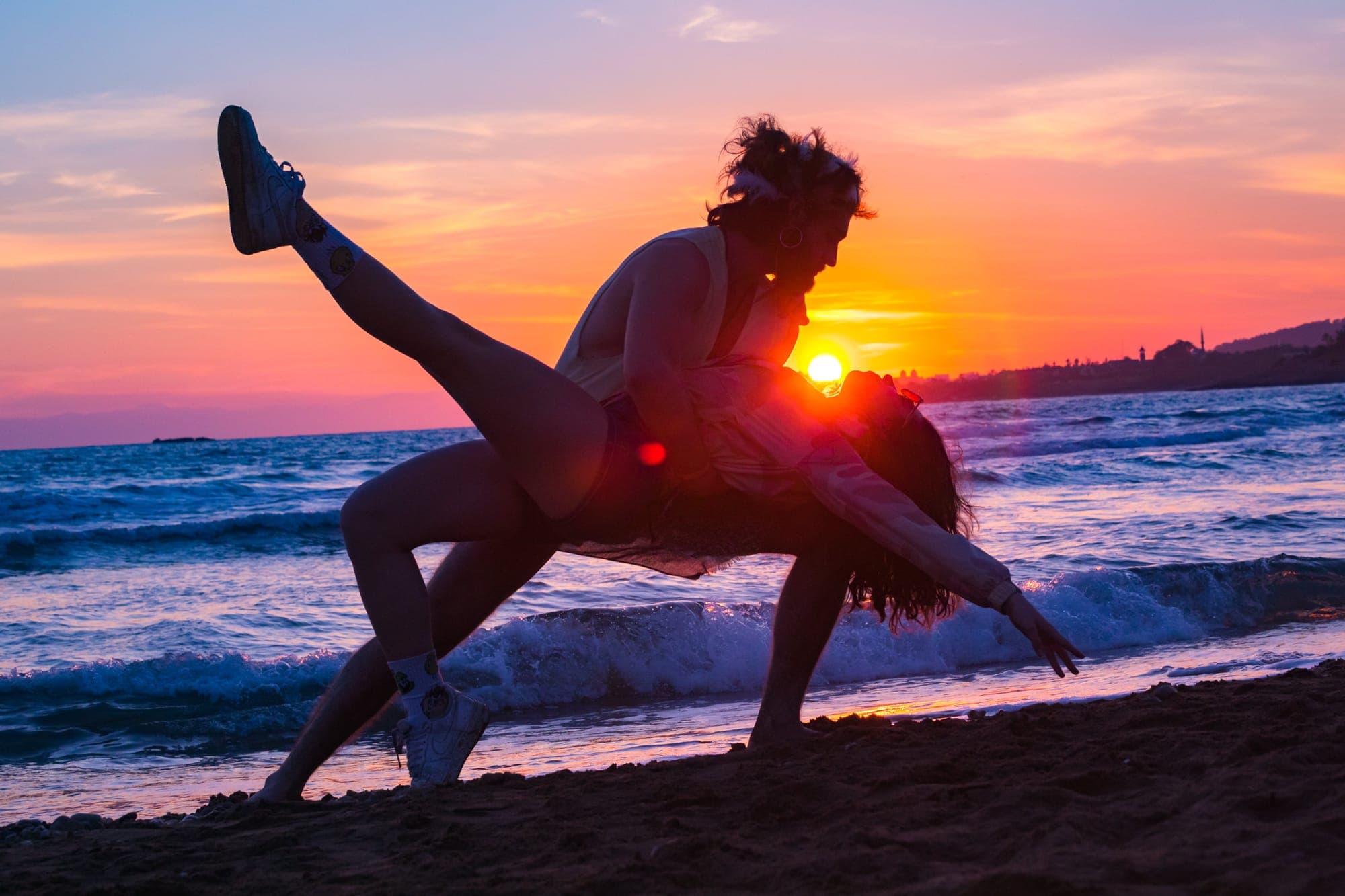 Magic Break Turkey, dancing couple in silhouette against a fiery sunset over the sea