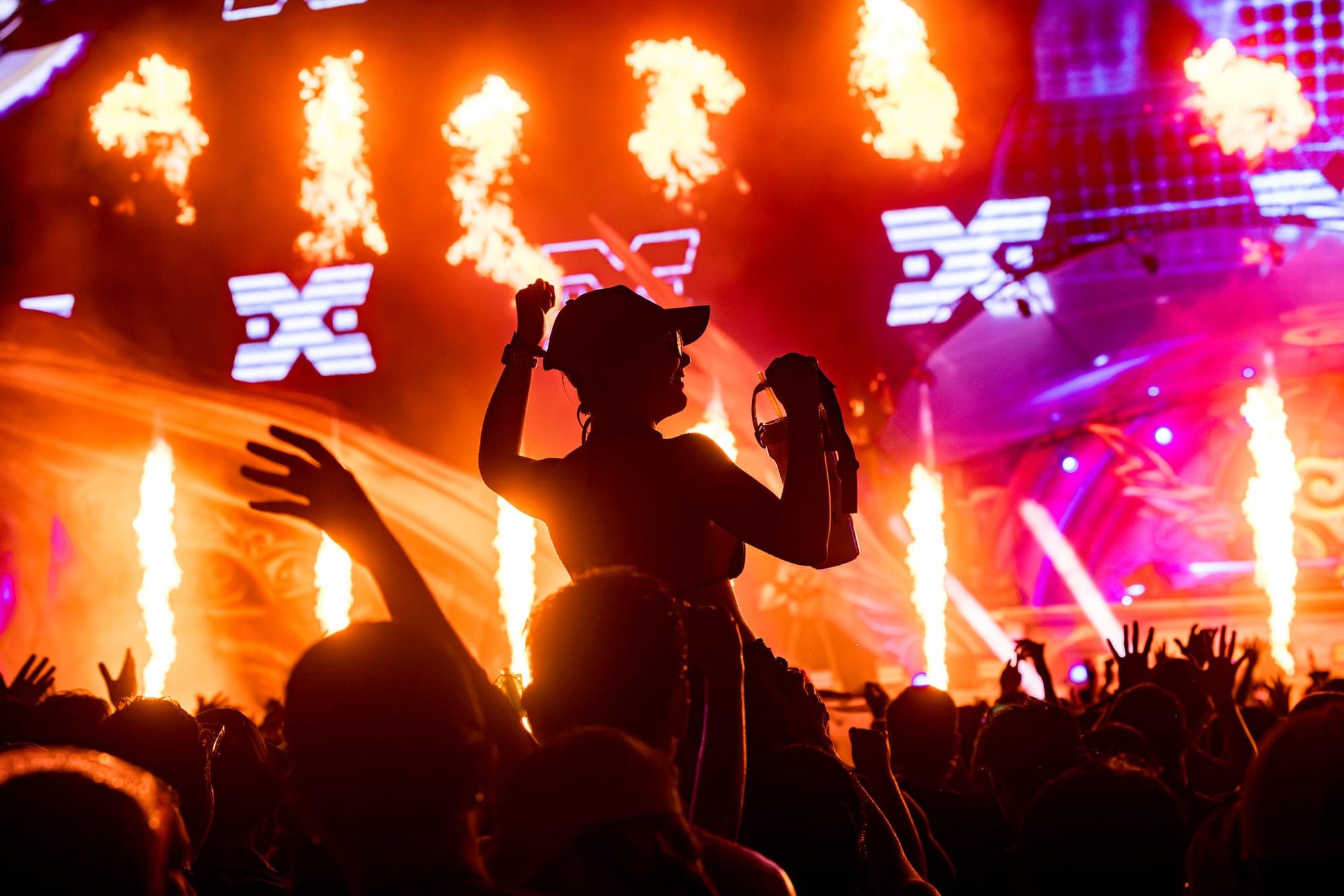 Siam Festival Bangkok, woman on shoulders in front of flames and lights